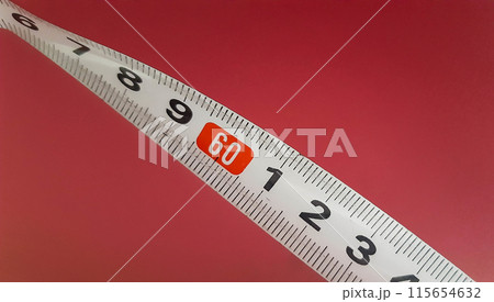 Measuring tape on a pink background. Construction tape measure a mark - 60 cm. Measuring tape on a pink background. Construction tape measure a mark - 60 cm. 115654632