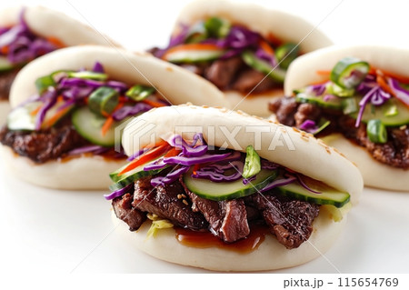 Three beef bao with cucumber and purple cabbage on a white backdrop 115654769