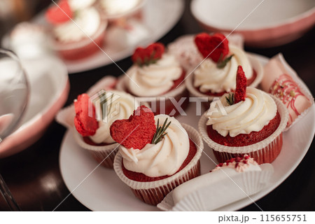red velvet cupcakes with white buttercream and heart decoration 115655751