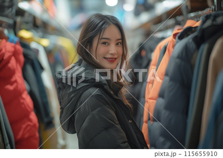 Woman in a winter jacket shopping for clothes in a cozy second hand shop 115655910