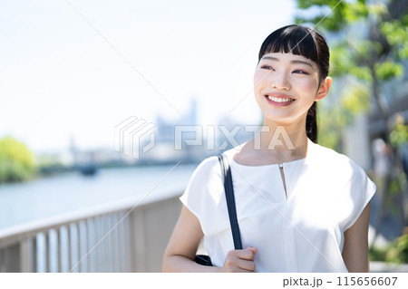 川沿いを歩く若い女性 115656607