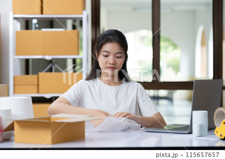 Small business entrepreneur woman packing product in mailing box for shipping from online store. Business online shipping and delivery concept. Small business entrepreneur woman packing product in mailing box for shipping from online store. Business online shipping and delivery concept. 115657657