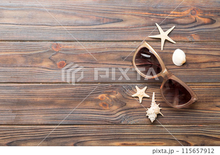sunglasses with seashell lying on table background. Sunglasses on summer background. Top view flat lay with copy space for text 115657912
