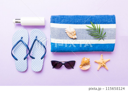 Summer holiday concept. Top view of beach towel, flip flop and sunscreen cream on table Top view with copy space for text 115658124