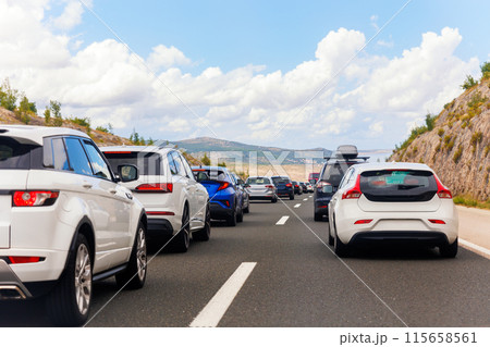 Back tail view of many cars stuck in row at highway road traffic jam warm hot sunny day at southern Europe. Automobile accident vehicle rush hour collapse. Transportation vacation seasonal stuck Back tail view of many cars stuck in row at highway road traffic jam warm hot sunny day at southern Europe. Automobile accident vehicle rush hour collapse. Transportation vacation seasonal stuck 115658561