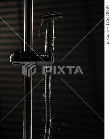 Bidet shower head leak water from hoses plumbing in bathroom as water clogged drop. Black background isolated. Leaking water from chromium stainless steel bidet shower head Bidet shower head leak water from hoses plumbing in bathroom as water clogged drop. Black background isolated. Leaking water from chromium stainless steel bidet shower head 115659097