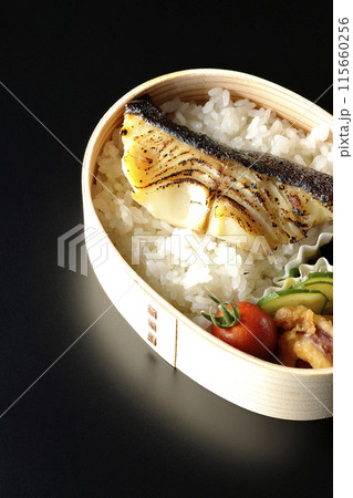 曲げわっぱに入った銀だらの西京焼き弁当を黒背景で撮影 115660256