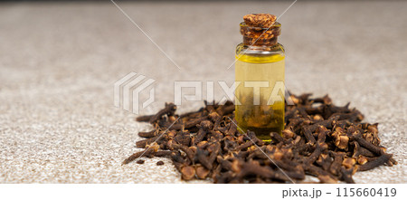 Natural clove oil in glass bottle among dried cloves Natural clove oil in glass bottle among dried cloves 115660419