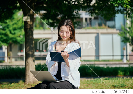 手帳にメモをする若い女性 手帳にメモをする若い女性 115662240