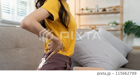 Woman experiencing back pain at home. Concept of physical discomfort 115662789