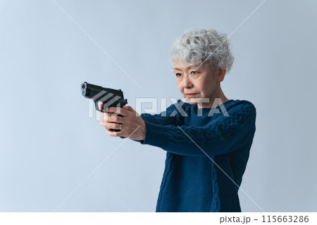 拳銃を構えるシニア女性 拳銃を構えるシニア女性 115663286