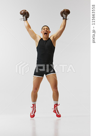 Achievement, success, victory. Full-length of emotions man, boxer in gloves showing his emotions after winning battle isolated on white background. 115663558