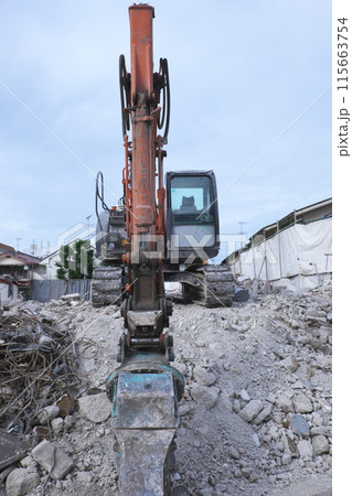 鉄筋コンクリート建築を解体するパワーショベル 115663754