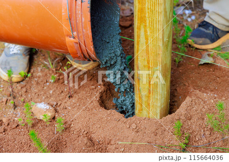 Construction of new timber fence and wooden fence posts using concrete Construction of new timber fence and wooden fence posts using concrete 115664036