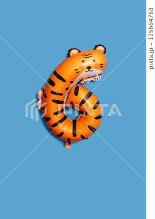 Balloon in the shape of a six and a tiger against a blue background 115664788