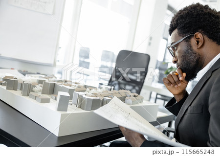 Skillful man architect working with blueprints in the office 115665248