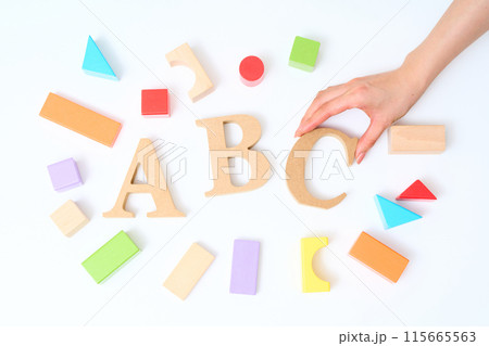 カラフルな積み木と「ABC」と並べられたアルファベットの木製ブロック 115665563