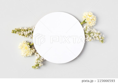 Spring flower frame made of white lilac and white daffodils on gray background with a place for text in the middle. Flat lay, copy space 115666593