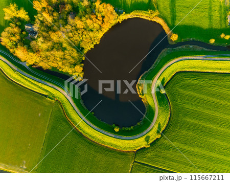 An aerial view of a road with curves. Road through the field. Image for wallpaper and background. An aerial view of a road with curves. Road through the field. Image for wallpaper and background. 115667211