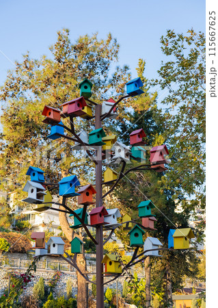 Multicolored birdhouses adorning a metal tree 115667625