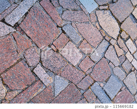 Background and pattern of stone, marble, granite and other rocks in daylight, green moss on pavement, sidewalk, road, street, avenue. Top view, textures and structures 115669182