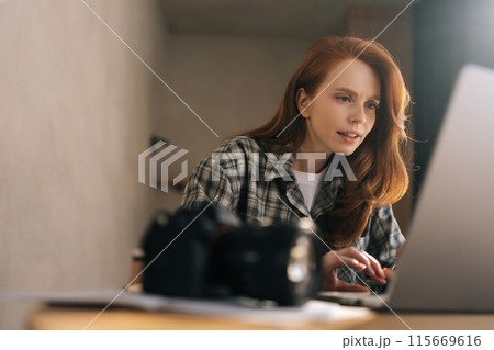 Close-up of young female editor working in home photo studio, retouching bad shot on laptop computer. Photographer drawing graphic with high quality image editing, enjoying making design of picture. Close-up of young female editor working in home photo studio, retouching bad shot on laptop computer. Photographer drawing graphic with high quality image editing, enjoying making design of picture. 115669616