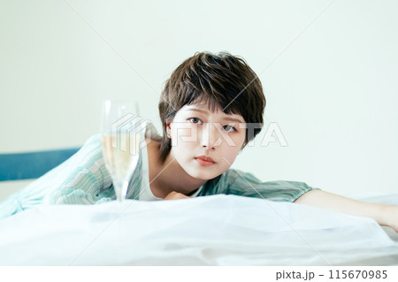 スパークリングワインの泡を見つめる若い女性 スパークリングワインの泡を見つめる若い女性 115670985
