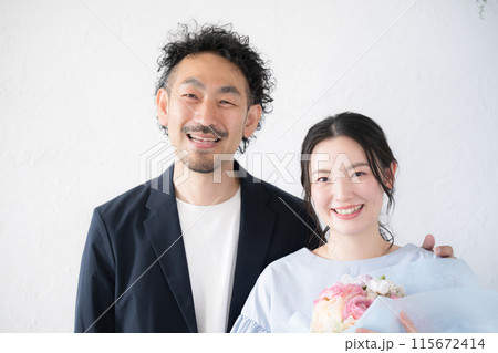 花束を持つ女性と男性　夫婦やカップルの記念日など 115672414