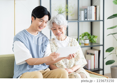 タブレットを見る祖母と孫 115673150
