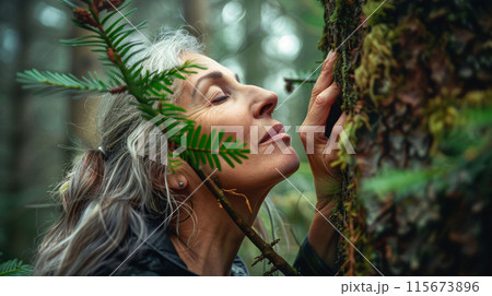Woman hugs tree in forest. Person's attraction to tree. New trend 115673896