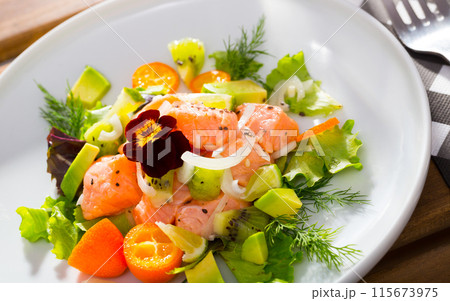 Ceviche from salmon with avocado, cumquat and green dill at plate with flower 115673975