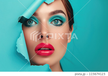 Woman peeking through torn blue paper 115674123