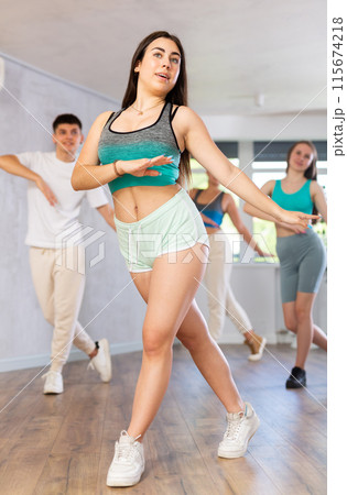 Girl teen perform choreographic exercise and teach energetic mobile social dance vogue with friends 115674218