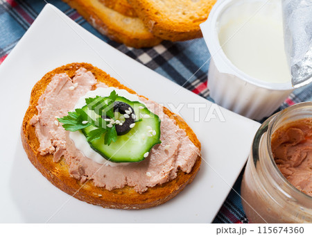 Toast with rillettes and fresh cheese on white plate 115674360