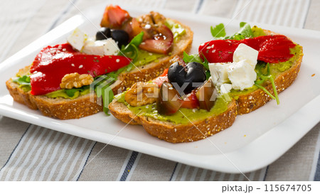 Toasts with guacamole, fresh vegetables, feta cheese Toasts with guacamole, fresh vegetables, feta cheese 115674705