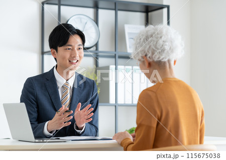 シニアの女性に営業するビジネスマン 115675038