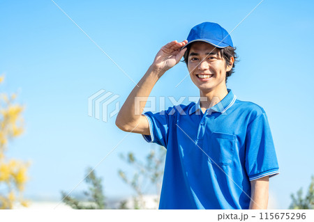 帽子をかぶった作業服の若い男性ドライバー 115675296