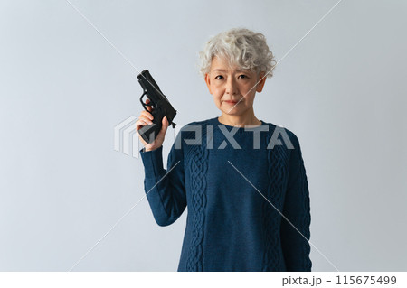 拳銃を構えるシニア女性 115675499