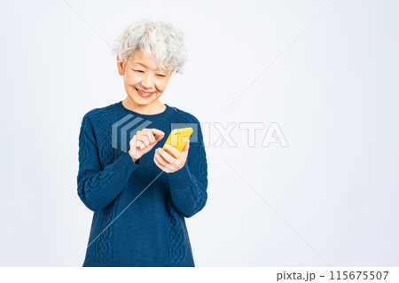 笑顔でスマホを使うシニア女性 笑顔でスマホを使うシニア女性 115675507