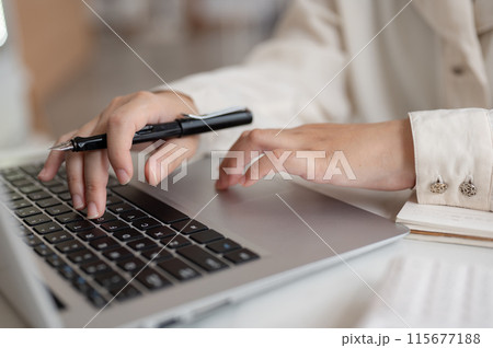 A close-up image of a businesswoman working on her laptop computer, typing on the laptop keyboard. A close-up image of a businesswoman working on her laptop computer, typing on the laptop keyboard. 115677188