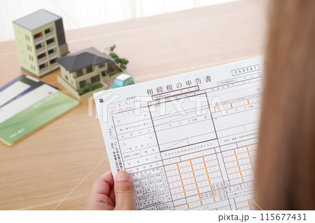 相続税の申告書を見つめる女性 相続税の申告書を見つめる女性 115677431