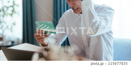 通帳を見る男性 115677835