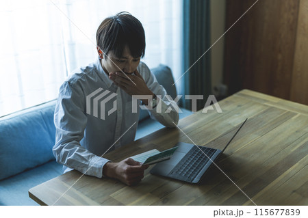 通帳を見る男性 115677839