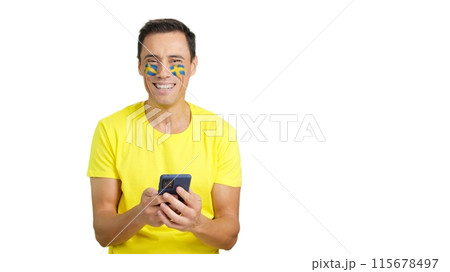 Swedish supporter looking at his mobile smiling and showing it. Swedish supporter looking at his mobile smiling and showing it. 115678497