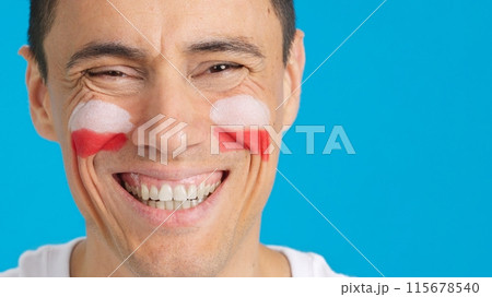 Man with a polish flag painted on the face smiling 115678540