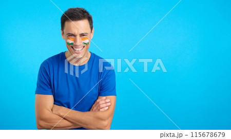 Man standing with indian flag painted on face smiling 115678679