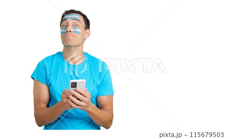 Argentina supporter looking at his mobile smiling and showing it. 115679503
