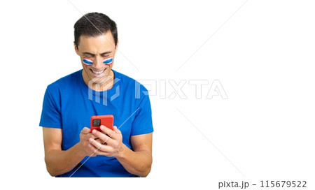 Thailand supporter looking at his mobile smiling and showing it. Thailand supporter looking at his mobile smiling and showing it. 115679522