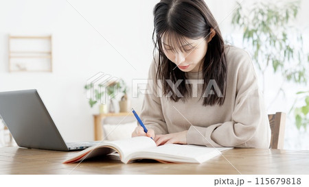 自宅で資格の勉強をする女性 115679818