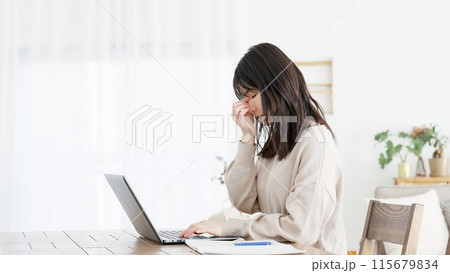 パソコン作業に目の疲れを感じる女性 115679834